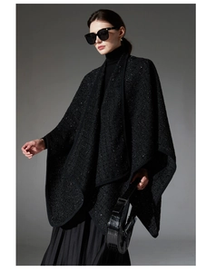 Close-up of black tweed wool shawl with shimmering sequins and elegant braided ribbon edge
