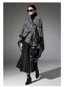 Detail of elegant black and white tweed poncho wrap for women with woven texture