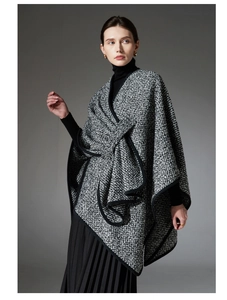 Close-up of thick boucle wool shawl featuring a knotted front and black piped edges