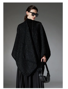 Detail view of black sequined tweed wool shawl with elegant texture and drape