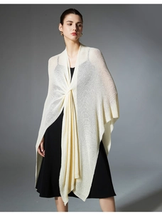 Detail of elegant cream knit shawl featuring a cross-knot design and delicate texture