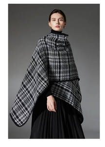 Detail of black and white houndstooth plaid poncho featuring woven wool texture and piping