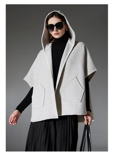 Vue détaillée d'un poncho à capuche gris clair avec de grandes poches plaquées