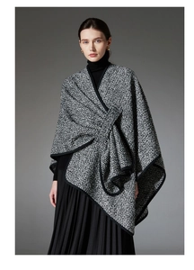 Detail view of the thick tweed material and black trim on this wool blend women's poncho