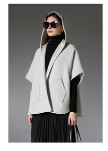 Vue détaillée du poncho à capuche gris clair avec grandes poches et texture laine