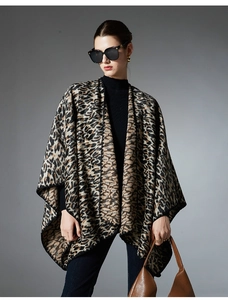 Detail of premium leopard print knit shawl with refined black stitched edges on a model
