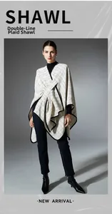 Detailed view of white knit shawl with black double-line grid pattern and piped edges