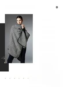 Detail of a thick black and white tweed knit shawl featuring premium contrast border trim