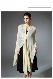 Detail of elegant cream knitted shawl with stylish front knot design and fine texture