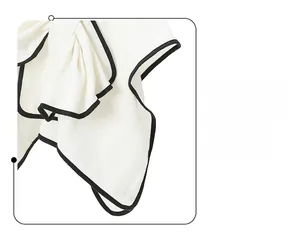 Close-up of white waffle texture fabric with black piping and decorative bow detail
