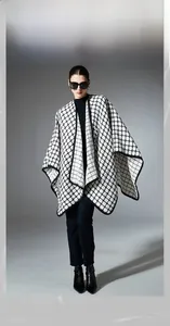 Detailed view of black and white plaid shawl featuring functional buckle fastener detail