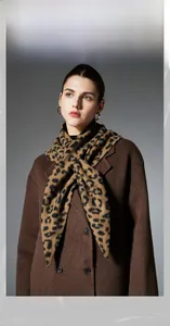 Dettaglio dello scialle a triangolo in maglia spessa con motivo leopardato marrone classico
