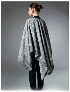 Detail of grey paisley knitted wool shawl showing intricate patterns and edge stitching