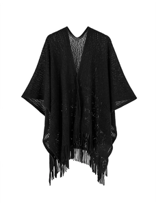 Gros plan du châle en maille ajourée noire montrant la texture et les longues franges