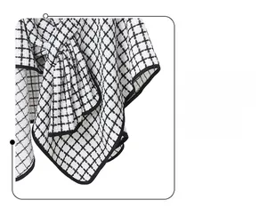 Detail of black and white plaid tweed fabric showing expert edge binding and texture