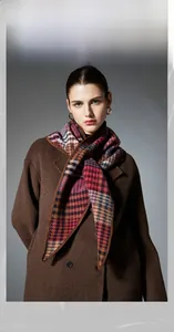 Detail view of multicolored plaid wool shawl scarf with houndstooth pattern and hemmed edge