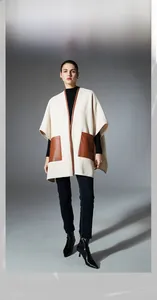 Detail of cream shawl featuring dark brown leather pockets and stylish edge piping