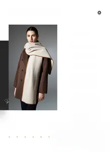Detail of cream knitted scarf with brown scalloped edge stitching on winter wool coat