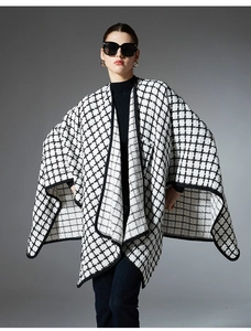 Detailed view of women's black and white plaid shawl cape with refined black piping edge