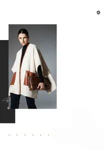 Detail view of cream white shawl featuring large brown leather pockets and Nordic design