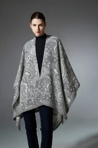 Detail of grey knitted shawl with paisley pattern and elegant texture worn by a model
