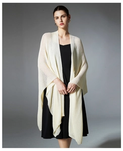 Close-up of cream white knit shawl featuring delicate fine mesh hollow texture and soft fabric