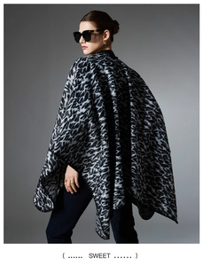 Detail of grey leopard print shawl showing the premium knit texture and fringed edges
