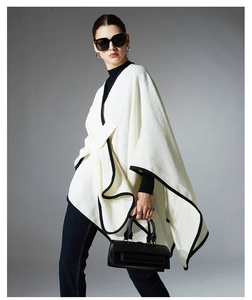 Detail of white knit shawl with contrast black edge showing waffle texture fabric