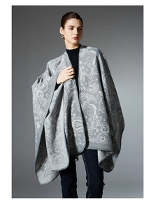 Close-up of grey paisley wool poncho featuring intricate white patterns and finished edges