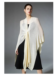 Detail of cream knitted shawl with twisted front knot design over a black dress