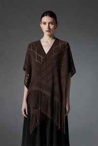 Détail du tricot ajouré à losanges et longues franges sur châle à pompons marron