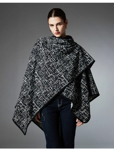Close-up of black and white textured knit shawl with black piped edges and premium fabric
