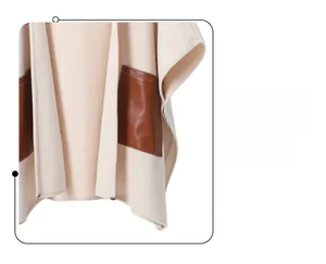 Detail of cream-colored shawl featuring brown leather pockets and contrast stitching