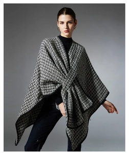 Detailed texture of black and white tweed poncho shawl with elegant ribbon-edged trim