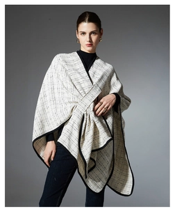Detail of white and black grid plaid poncho with elegant black hem and tweed texture