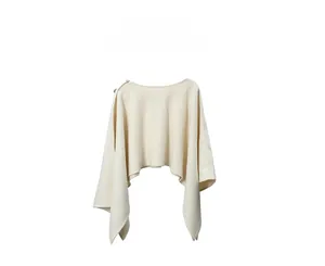 Dettaglio di uno scialle in maglia crema con trama morbida e bottoni decorativi