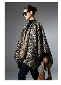 Detail shot of leopard print knit shawl featuring elegant batwing sleeve design on model