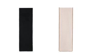 Detail of black and beige knitted scarves featuring contrasting hand-stitched borders