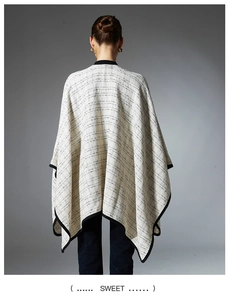 Detailed back view of a plaid poncho wrap with black piping and high-quality knit texture