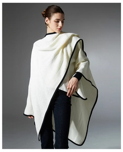 Close-up of white waffle knit shawl with black trim edge for fall and winter seasons