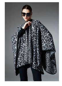 Detail view of cross-front leopard print shawl worn over a black turtleneck top