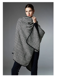 Detailed view of black and white melange wool shawl with black fabric piped edges