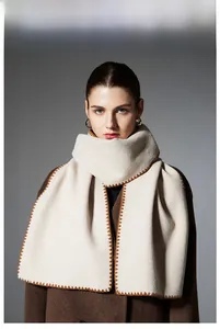 Detail of soft cream winter scarf featuring elegant brown wavy stitch edge embroidery