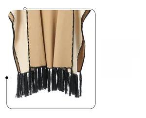 Detail of khaki shawl featuring black tassel fringe and decorative zigzag stitching texture
