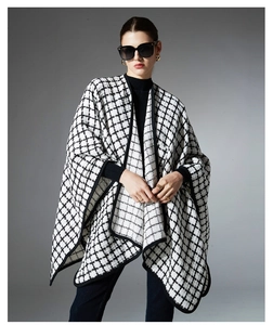 Detail of black and white plaid shawl featuring premium knit texture and contrast piping
