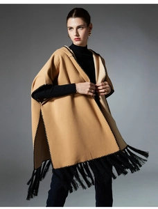Detail of camel wool-like hooded poncho with black fringe trim and woven edges