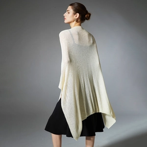 Elegant beige openwork knit shawl wrap for women over a black sleeveless dress
