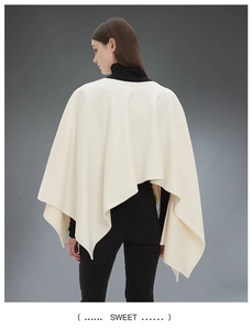 Vista posteriore di un elegante poncho in maglia bianco avorio con orlo irregolare e bottoni
