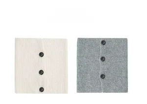 Detail of knit neck warmer showing vertical ribbed texture and three black buttons