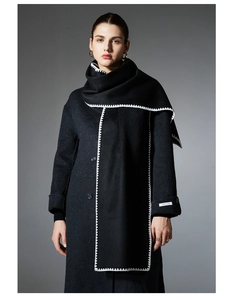 Detail of white blanket stitch embroidery on a black wool coat and matching long scarf